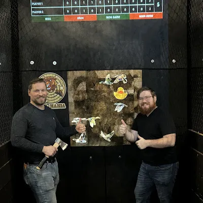 Friends enjoying axe throwing at Axe-Mania, an indoor entertainment venue in Kingwood, TX.